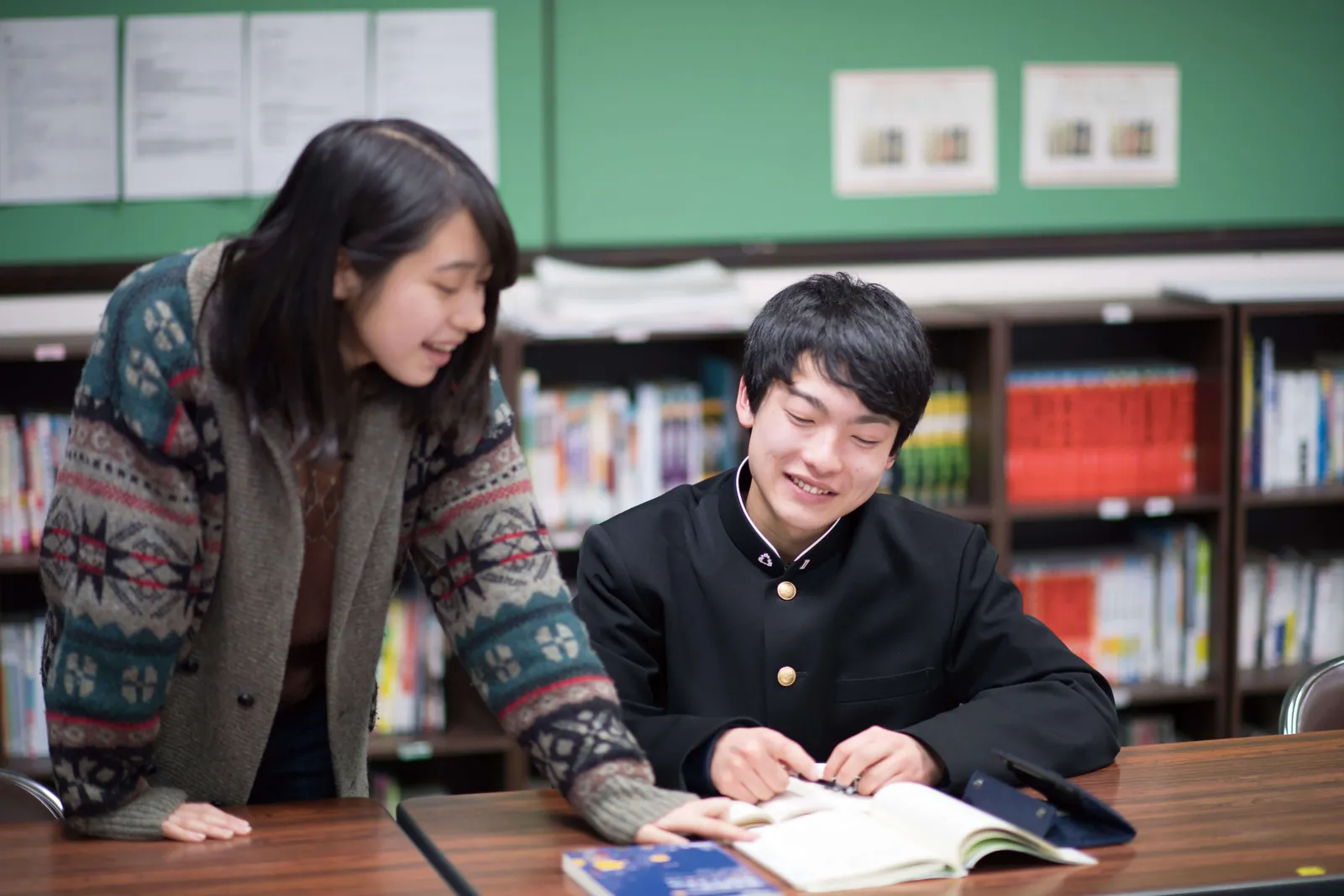 図書室で生徒とスタッフが一緒に本を読んでいる写真